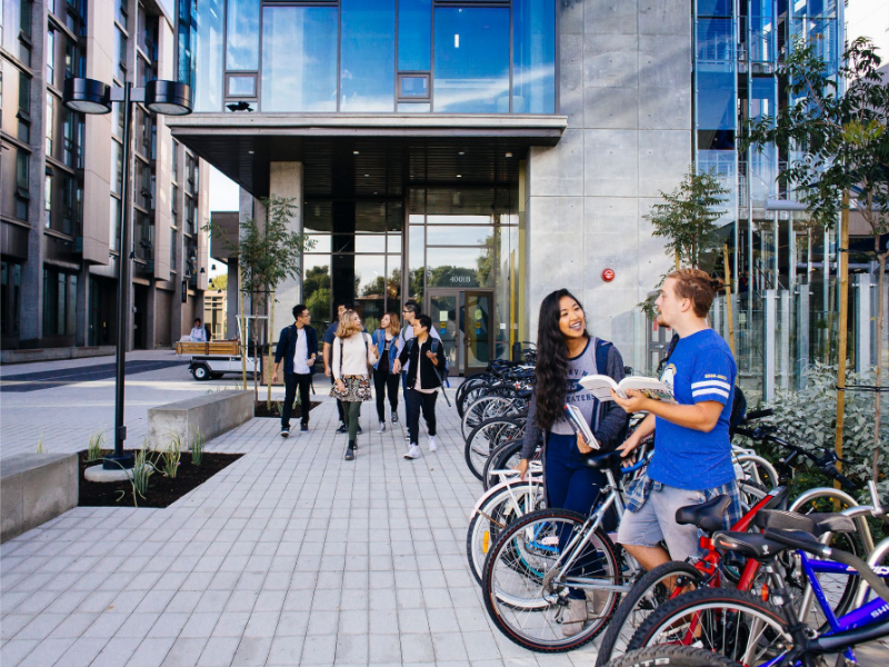 students at a bike rack in front of mesa towers
